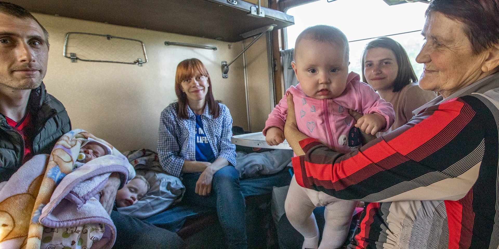 23-year-old Yulia (center) gave birth to a son two weeks ago in Toretsk. She goes with her husband Kostyantyn (left, holding her son in her arms) and neighbors to Dnipro (Photo: Oleksandr Medvedev /NV)