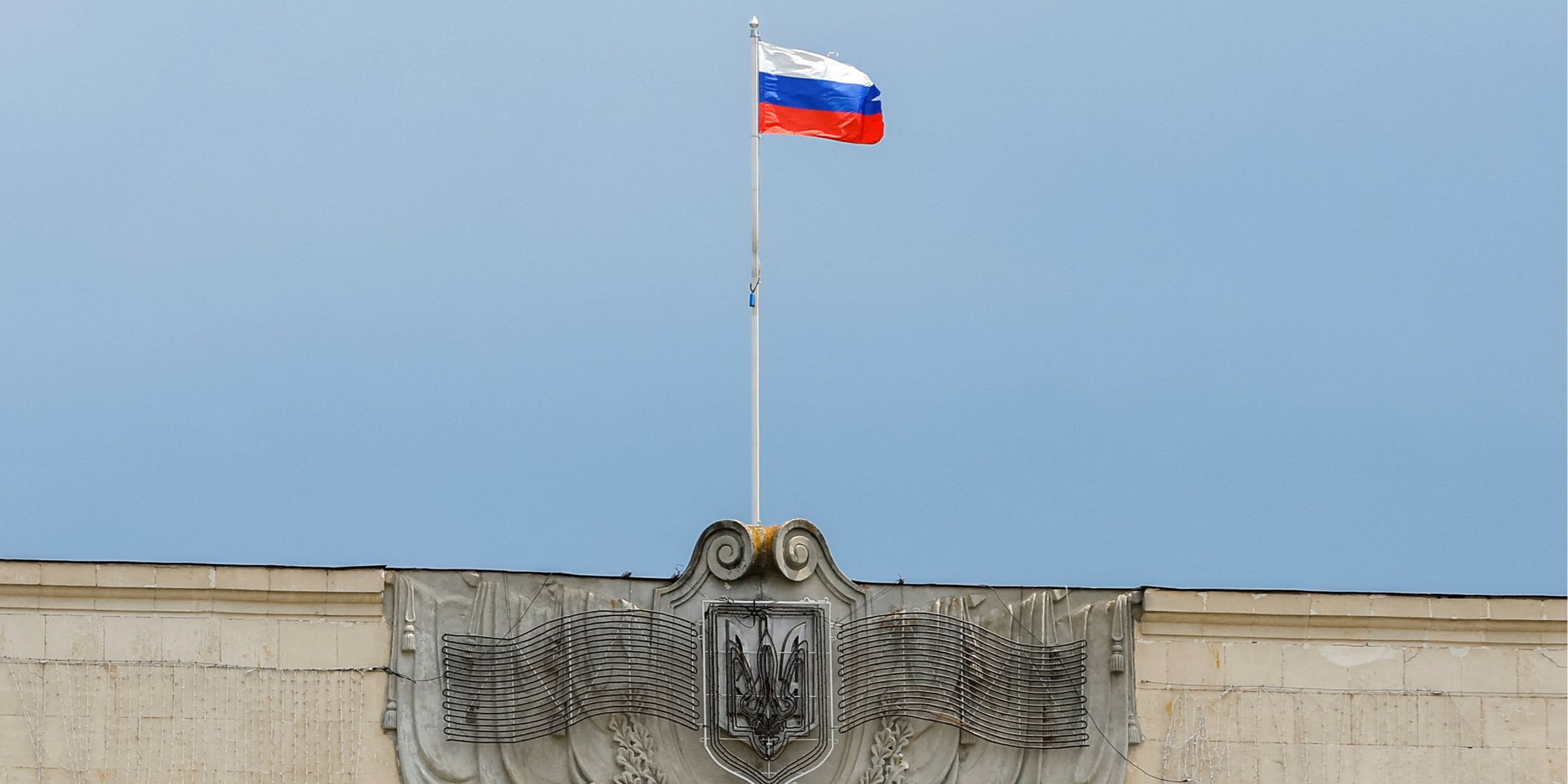 Російський прапор над українським гербом на&nbsp;будівлі Херсонської облради (Фото: REUTERS/Alexander Ermochenko)