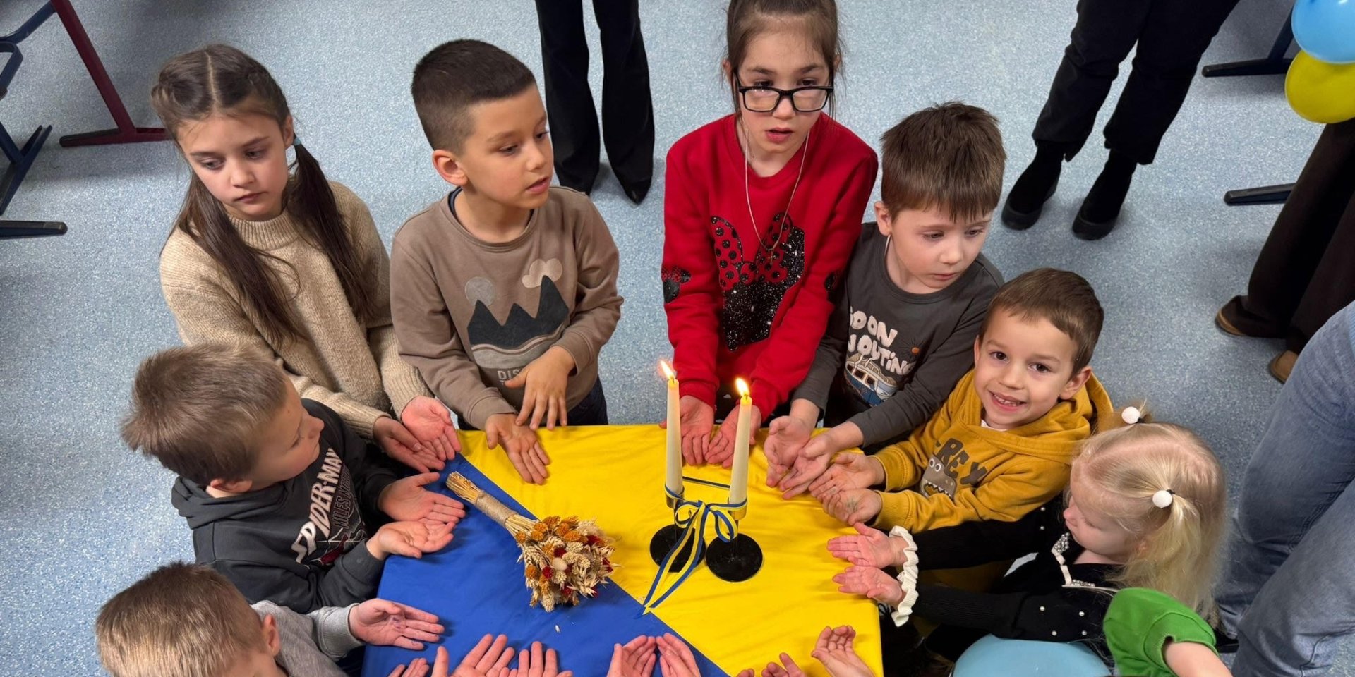 Ukrainian children gather around a table decorated in national colors during a community event at a Ukrainian school in Germany. (Photo: Provided by Oksana Pechenega, director of a Ukrainian school in Osnabrück)