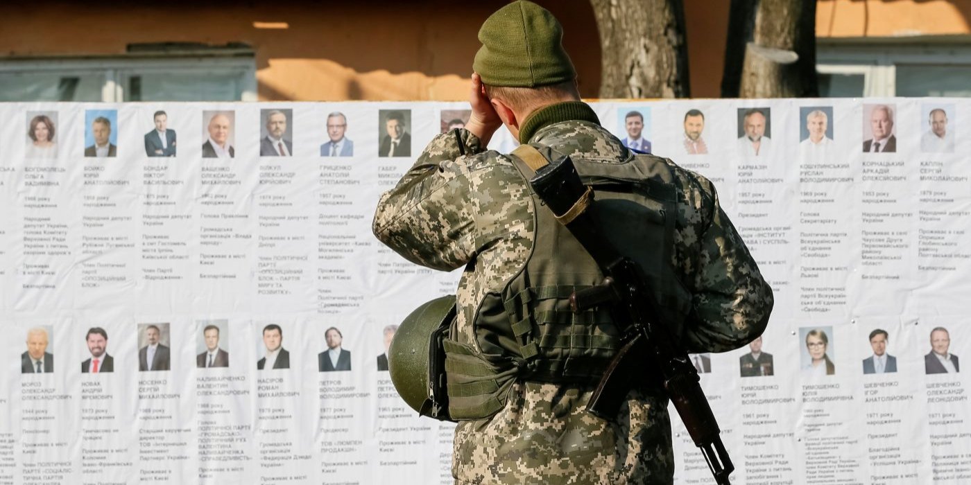 Украинский военнослужащий читает информацию о&nbsp;кандидатах в&nbsp;президенты на&nbsp;избирательном участке вблизи линии фронта, во&nbsp;время президентских выборов в&nbsp;селе Зайцево, 31&nbsp;марта 2019 год (Фото: REUTERS/Gleb Garanich)