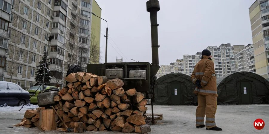 A State Emergency Service employee stands against the backdrop of a sprawling tent camp in the Troyeschyna district of the capital (Photo: Serhiy Okunev, NV)