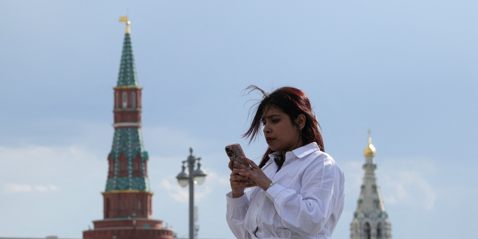 Женщина смотрит в&nbsp;свой мобильный телефон в&nbsp;центре Москвы, 4&nbsp;мая 2026 года (Фото: REUTERS/Ramil Sitdikov)