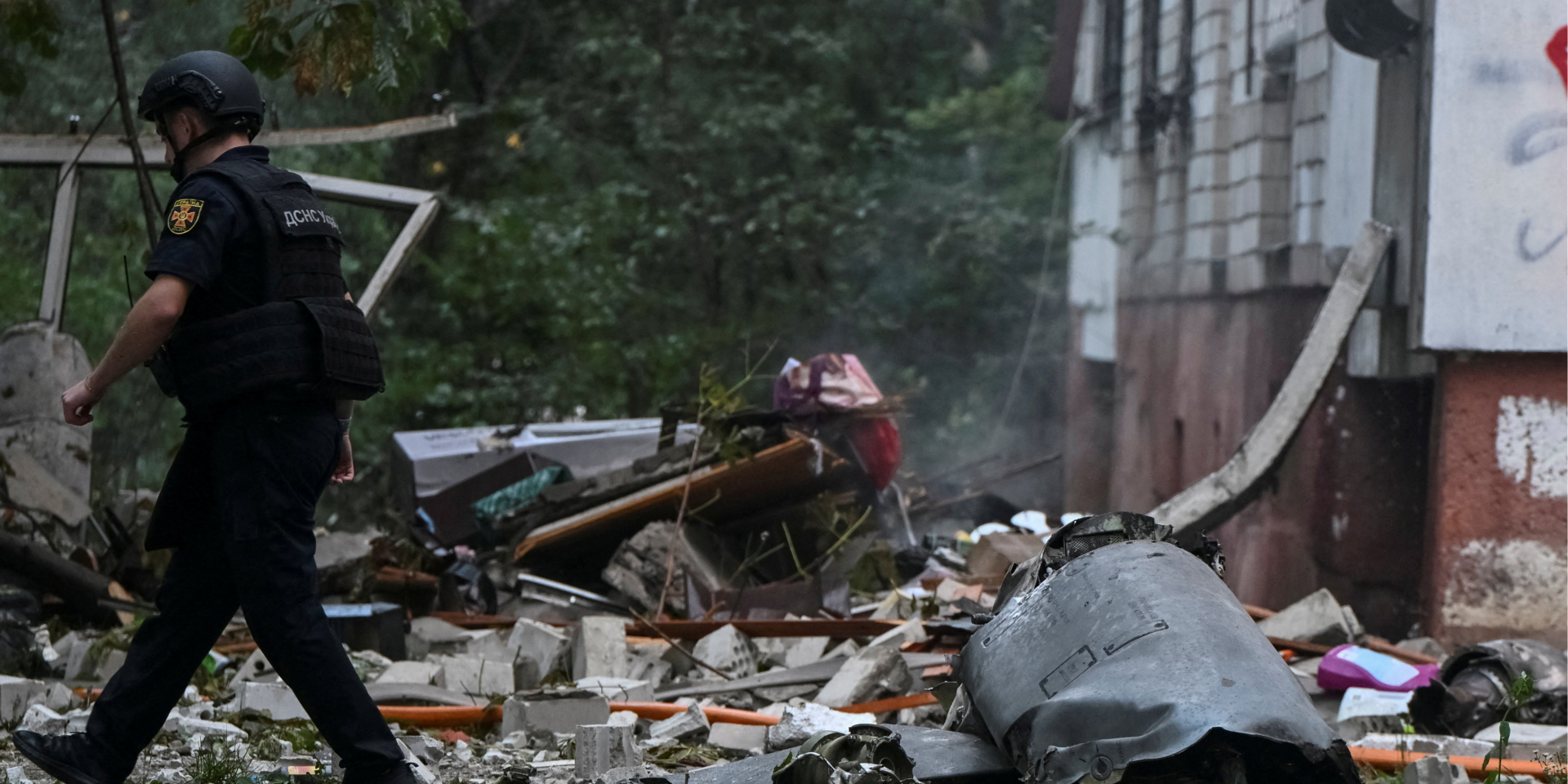 Рятувальник іде поруч із уламком російської крилатої ракети на місці влучання в&nbsp;багатоквартирний будинок у&nbsp;Львові, 30 липня 2026 року (Фото: REUTERS/Stringer)