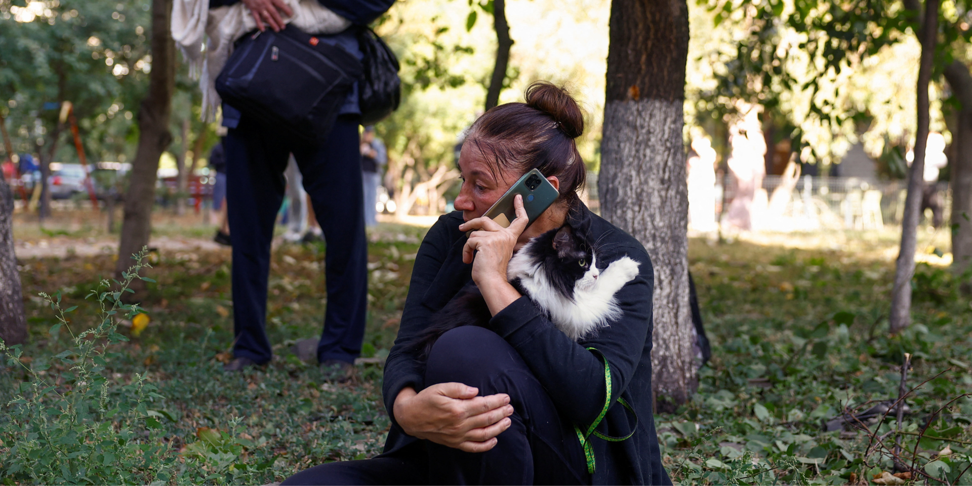 A woman holds her cat while she speaks on a mobile phone near her apartment building, hit by a Russian drone strike, September 9, 2026 (Photo: REUTERS)