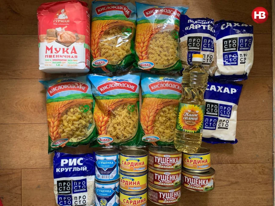 Visible on the photograph are 5 packages of macaroni, made in the Russian town of Kislovodsk, 1 package of Gurman-brand flour (1.8kg), 1 package each of Artek wheat groats and rice, 2 packages of sugar, 1 liter of sunflower oil, 2 cans of sugary condensed milk, 4 cans of canned fish, and 4 cans of canned stewed beef. (Фото: NV)