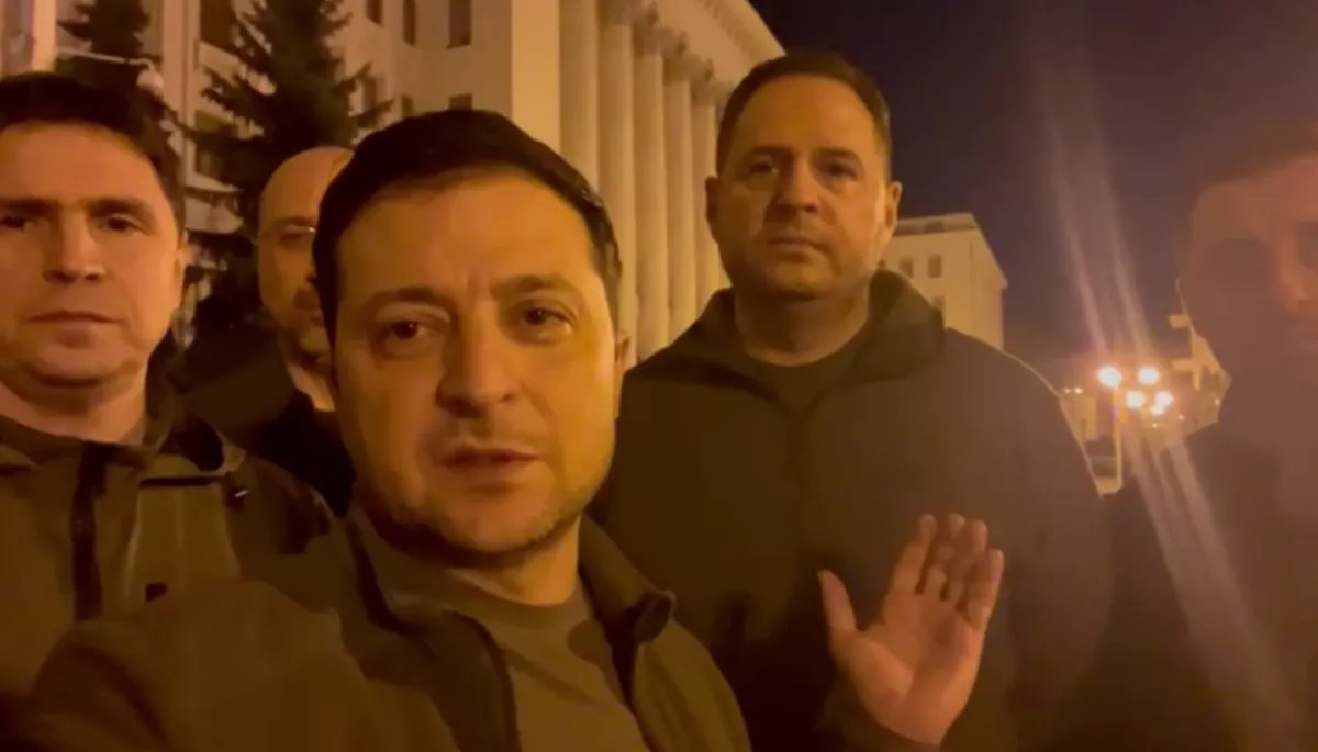 25 лютого Володимир Зеленський записав відеозвернення біля ОП, показавши команду, яка з ним залишилася на Банковій. Серед присутніх - прем'єр Денис Шмигаль (позаду президента), голова ОП Андрій Єрмак (у центрі), голова фракції СН Давид Арахамія (праворуч), радник голови ОП Михайло Подоляк (ліворуч). Керівника СБУ Івана Баканова нема (Фото: скріншот з відеозвернення президента України)