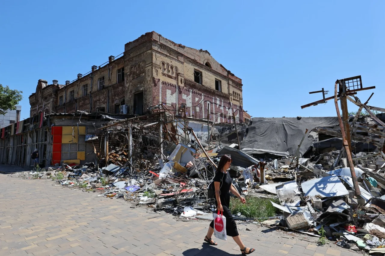 A woman walks by a destroyed building in Russian-occupied Mariupol (Фото: REUTERS/Alexander Ermochenko)
