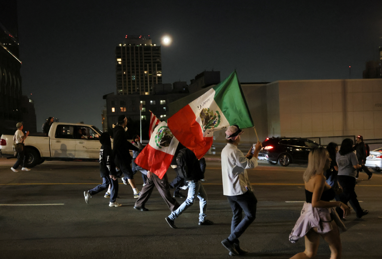 Demonstrators walk through downtown Los Angeles after curfew begins amid protests against U.S. anti-immigration measures on June 10, 2025. (Фото: REUTERS/Leah Millis)