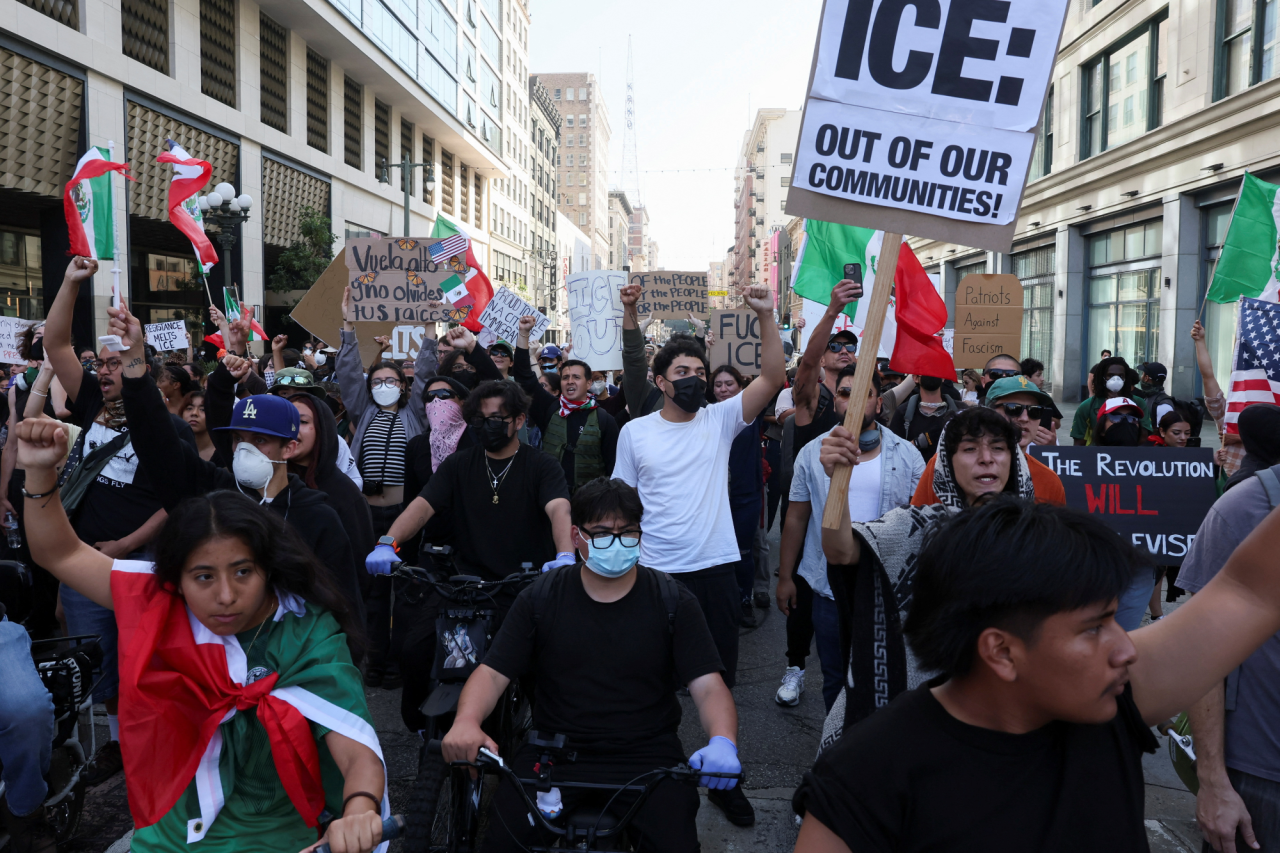Demonstrators hold signs and flags, including anti-ICE slogans, during protests in downtown Los Angeles, California, U.S., on June 10, 2025. (Фото: REUTERS/Leah Millis)